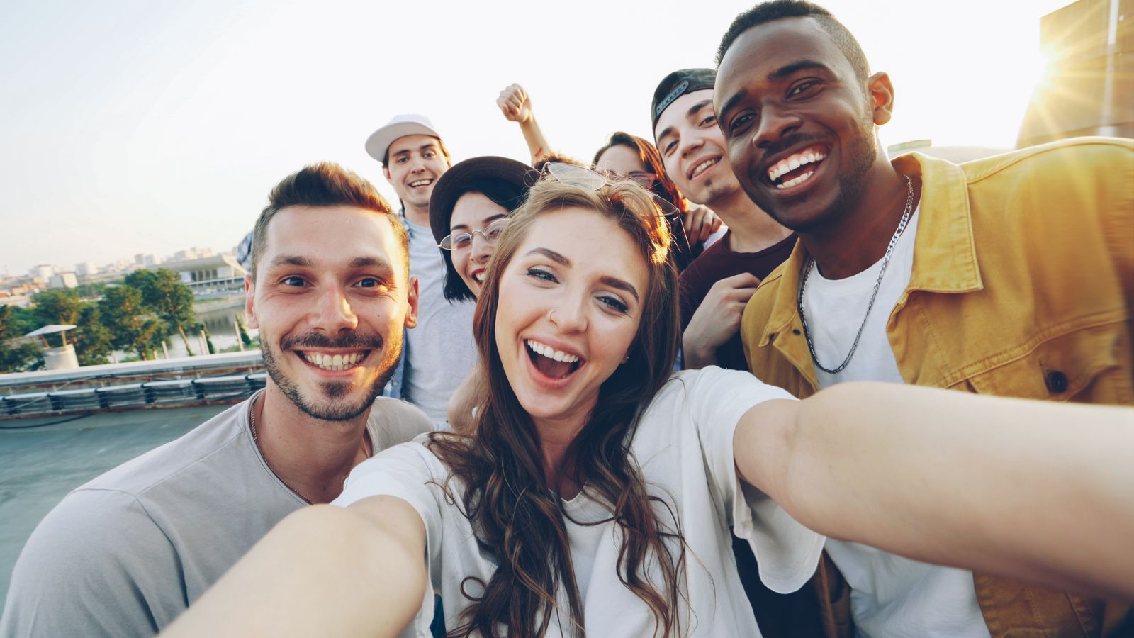 A diverse group of young adults smiling together outdoors