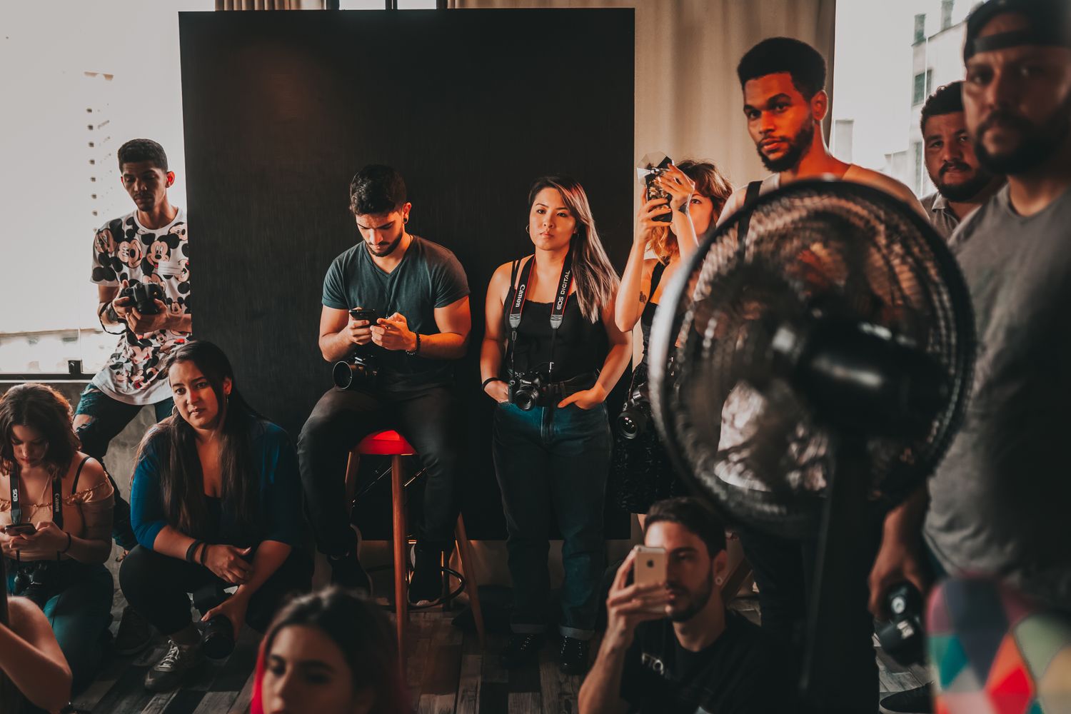 A diverse group of young adult photographers collaborating with cameras